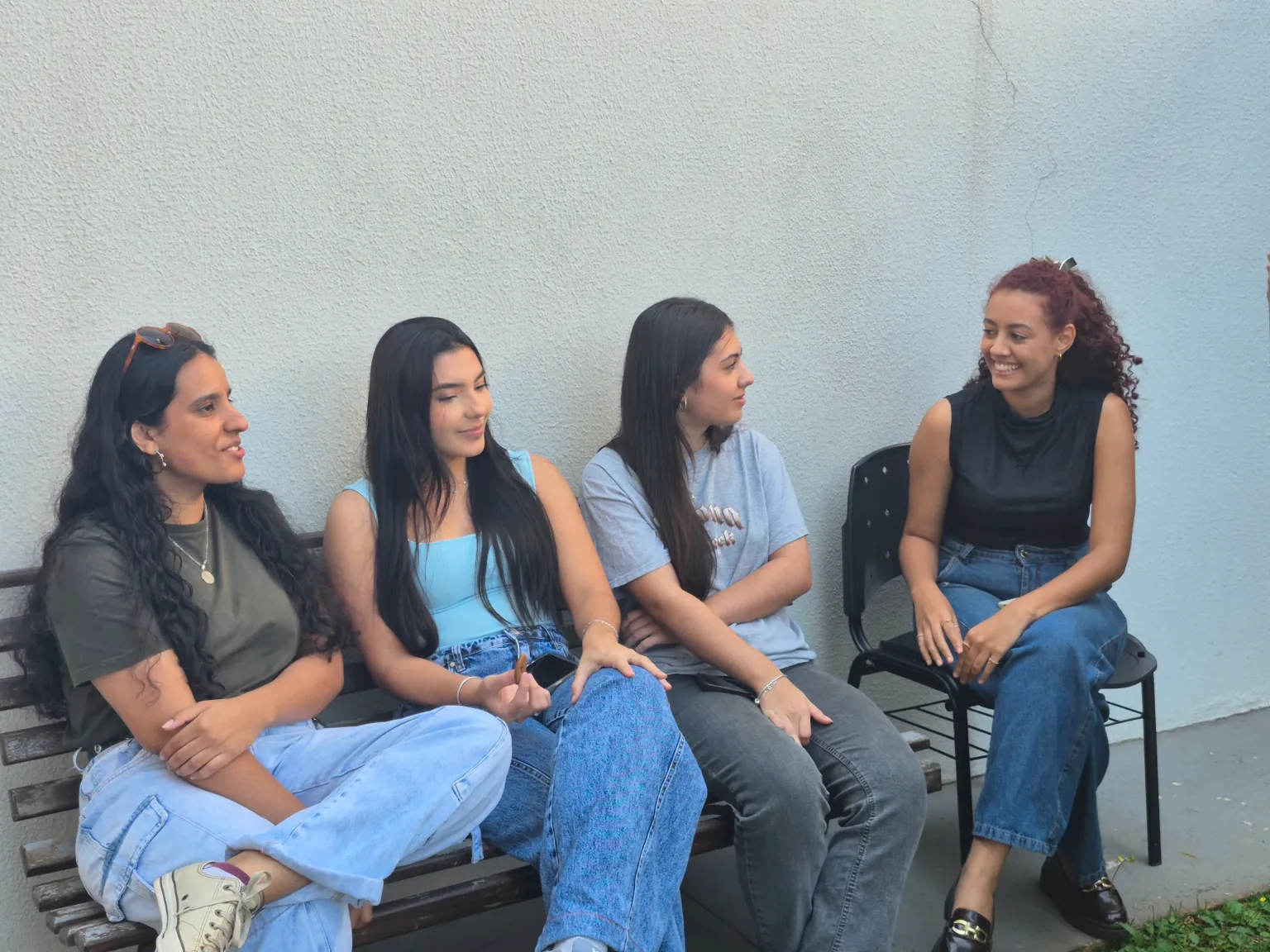 Quatro alunas do Go English conversando sentadas no pátio da escola